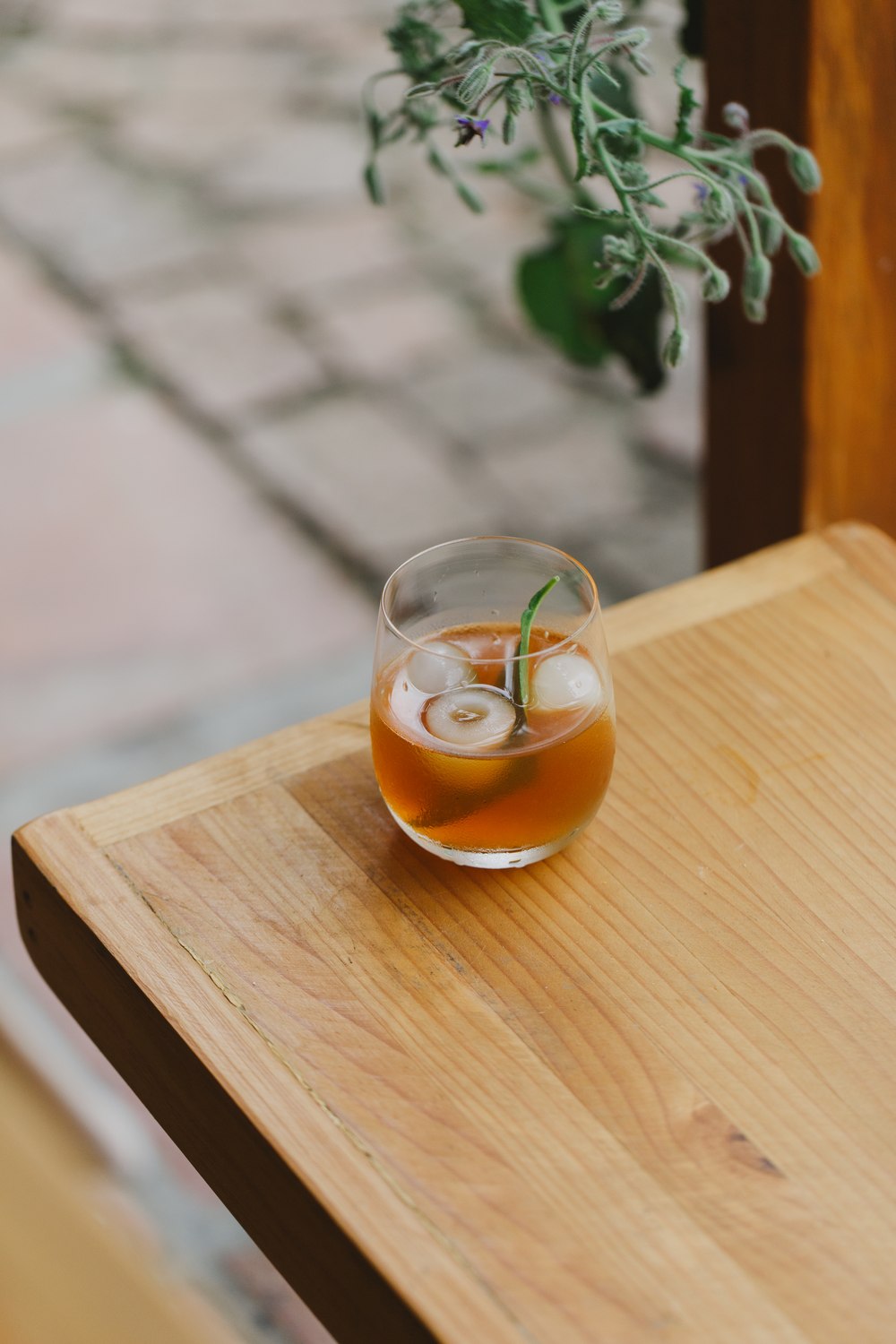 A chilled drink with citrus and fresh herbs on a wooden table at Melfort