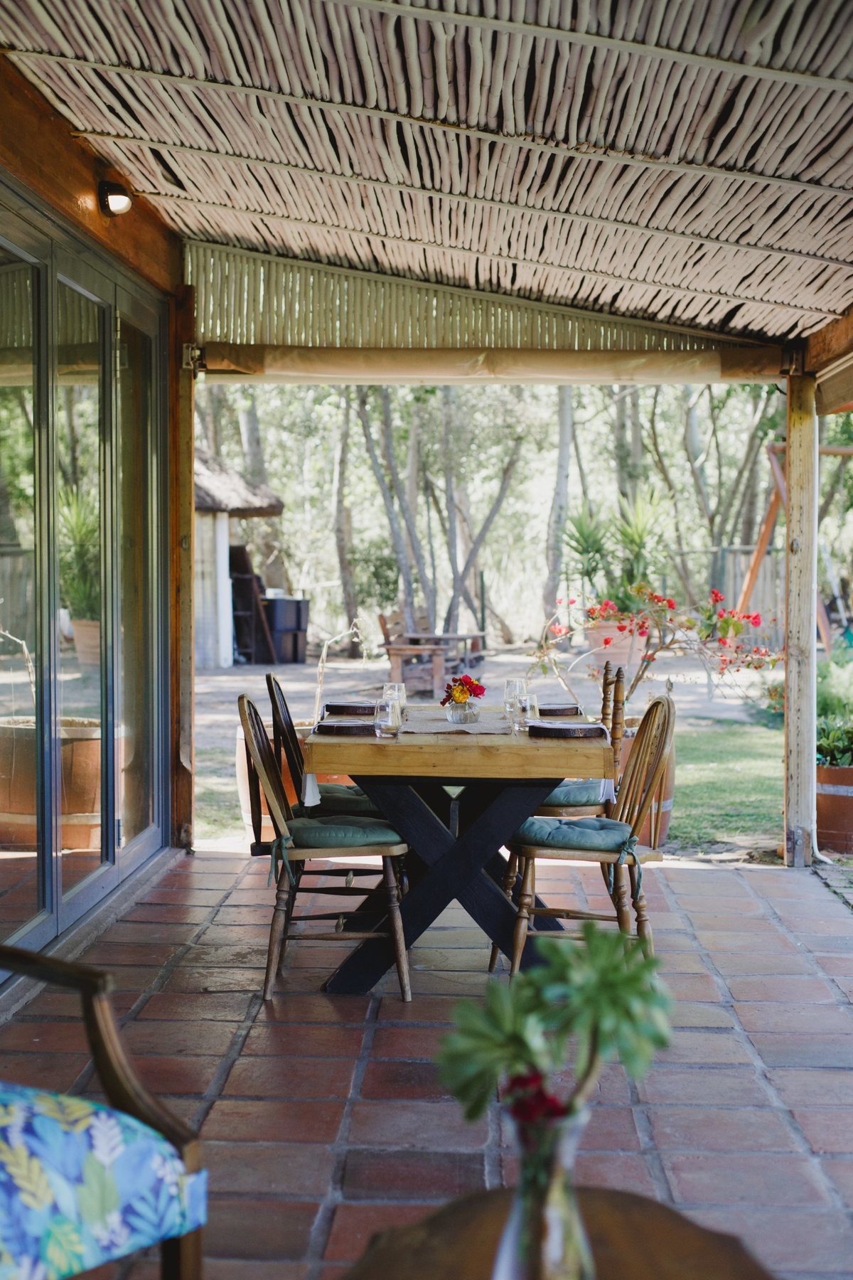 A table set with flowers on Melfort’s covered veranda, looking into the garden