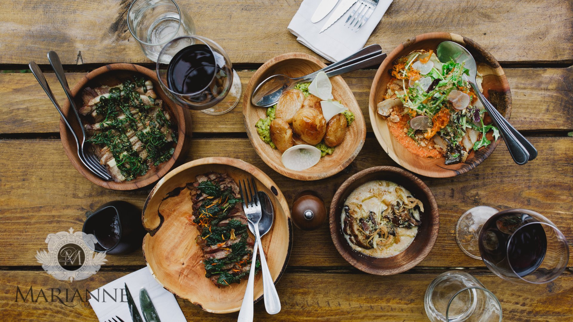 A generous spread of Melfort dishes and wine across a wooden table