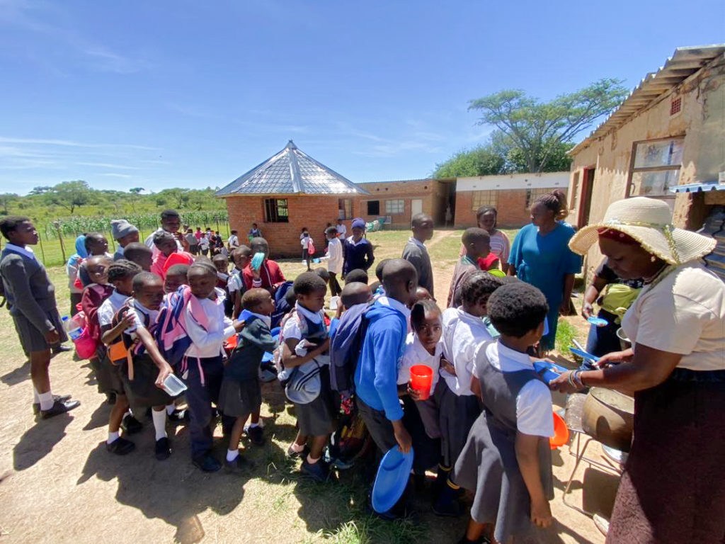 Children gathering outside Rock of Wisdom School before entering the building